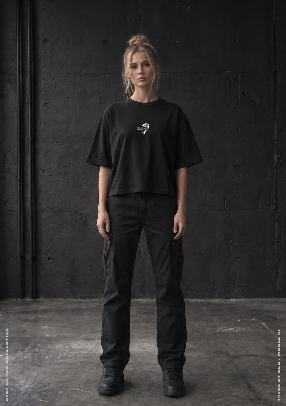 Model von vorne im schwarzen Rave Intoxication Cropped Oversized T-Shirt mit kleinem weißem Rave Intoxication Logo auf der Brust vor Betonwand, Techno Streetwear von Stay Lifted Collective
