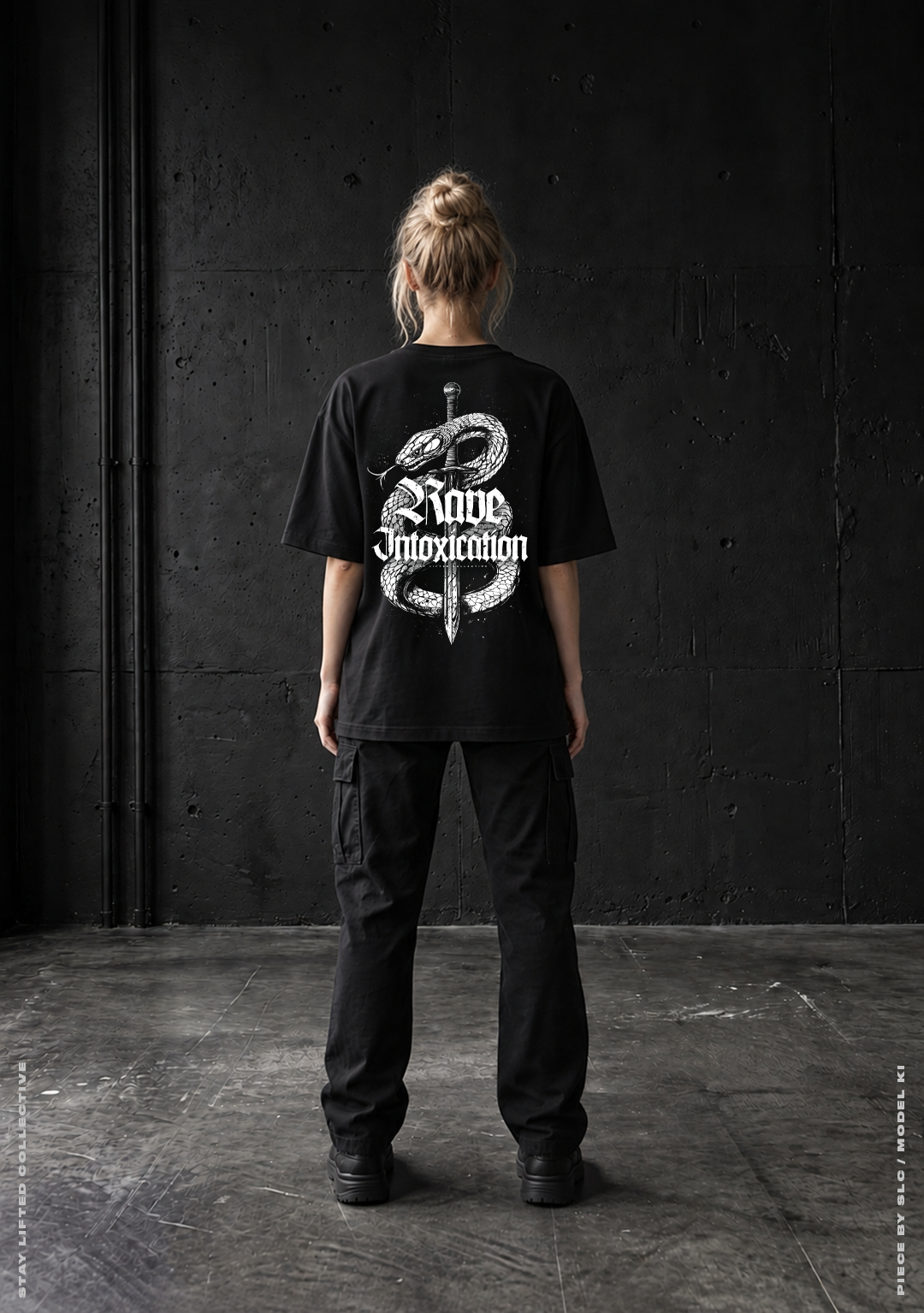 Model von hinten im schwarzen Rave Intoxication Oversized T-Shirt mit weißem Schlange und Dolch Rückenprint vor Betonwand, Techno Streetwear von Stay Lifted Collective