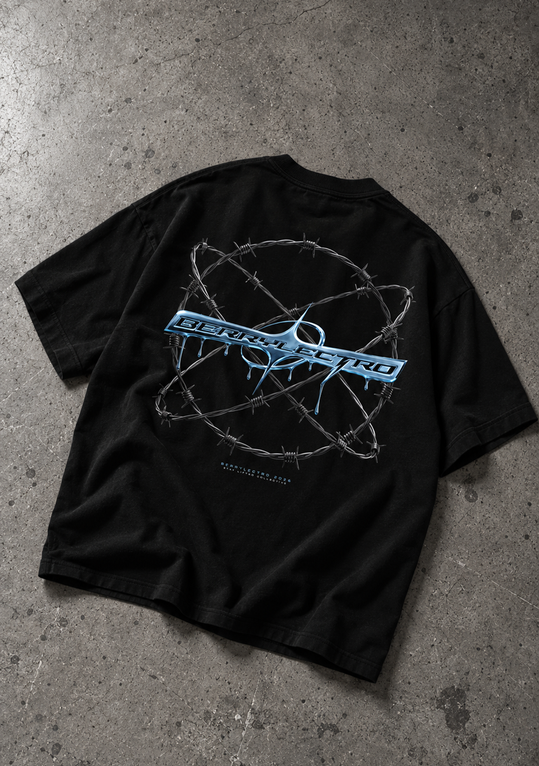 Schwarzes BERRYLECTRO Oversize T-Shirt auf grauem Betonboden, Rückansicht mit großem blauem Chromlogo im Stacheldrahtring