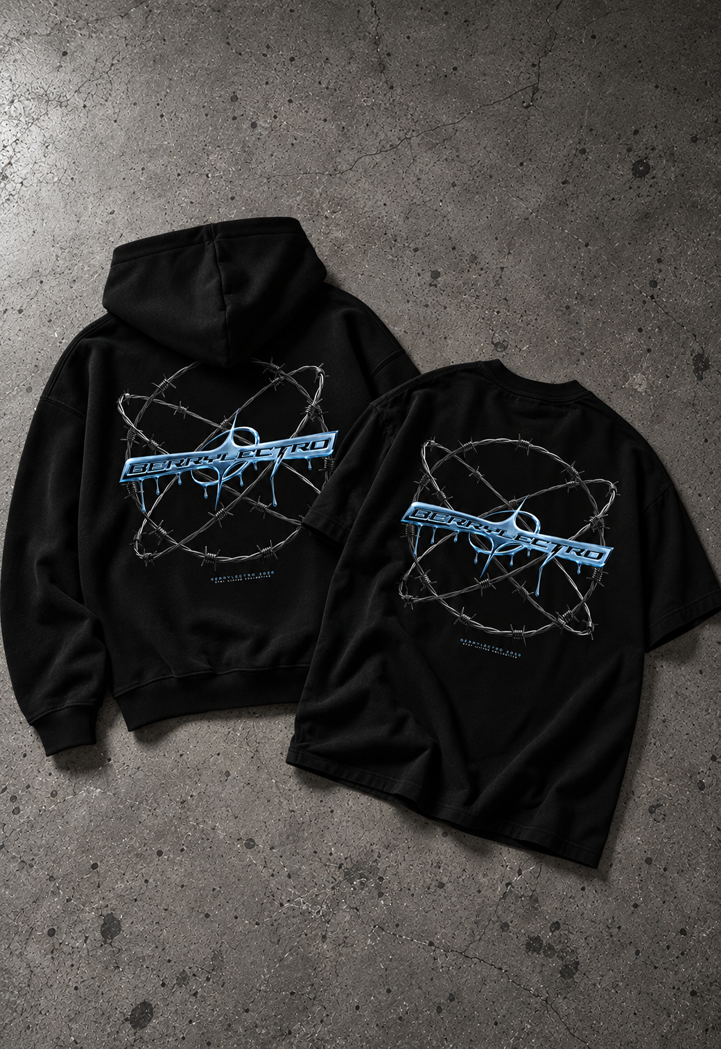 Schwarzer BERRYLECTRO Oversize Hoodie und Oversize T-Shirt auf grauem Betonboden, beide von hinten mit blauem Chromlogo im Stacheldrahtring