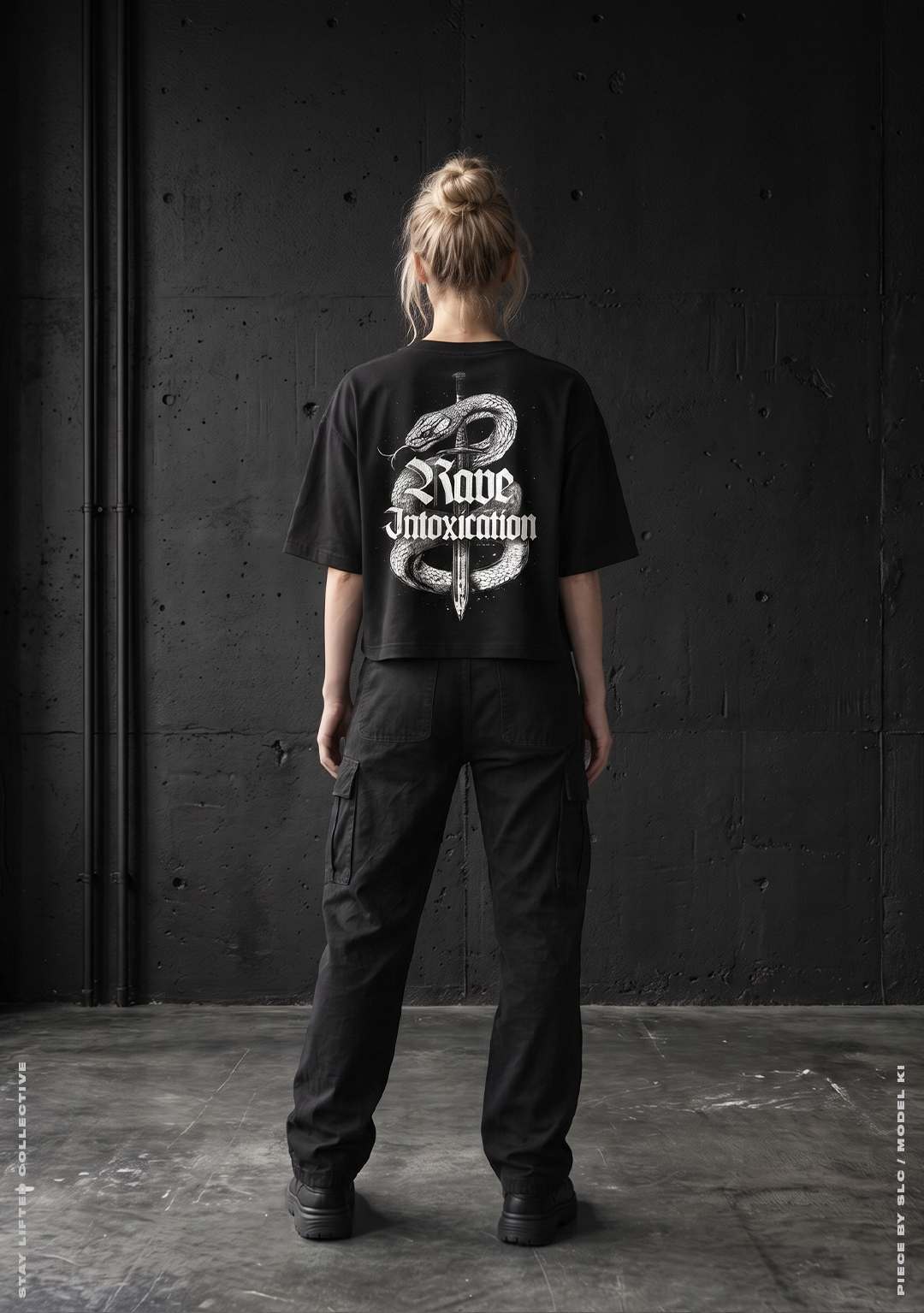 Model von hinten im schwarzen Rave Intoxication Cropped Oversized T-Shirt mit weißem Schlange und Dolch Rückenprint vor Betonwand, Techno Streetwear von Stay Lifted Collective